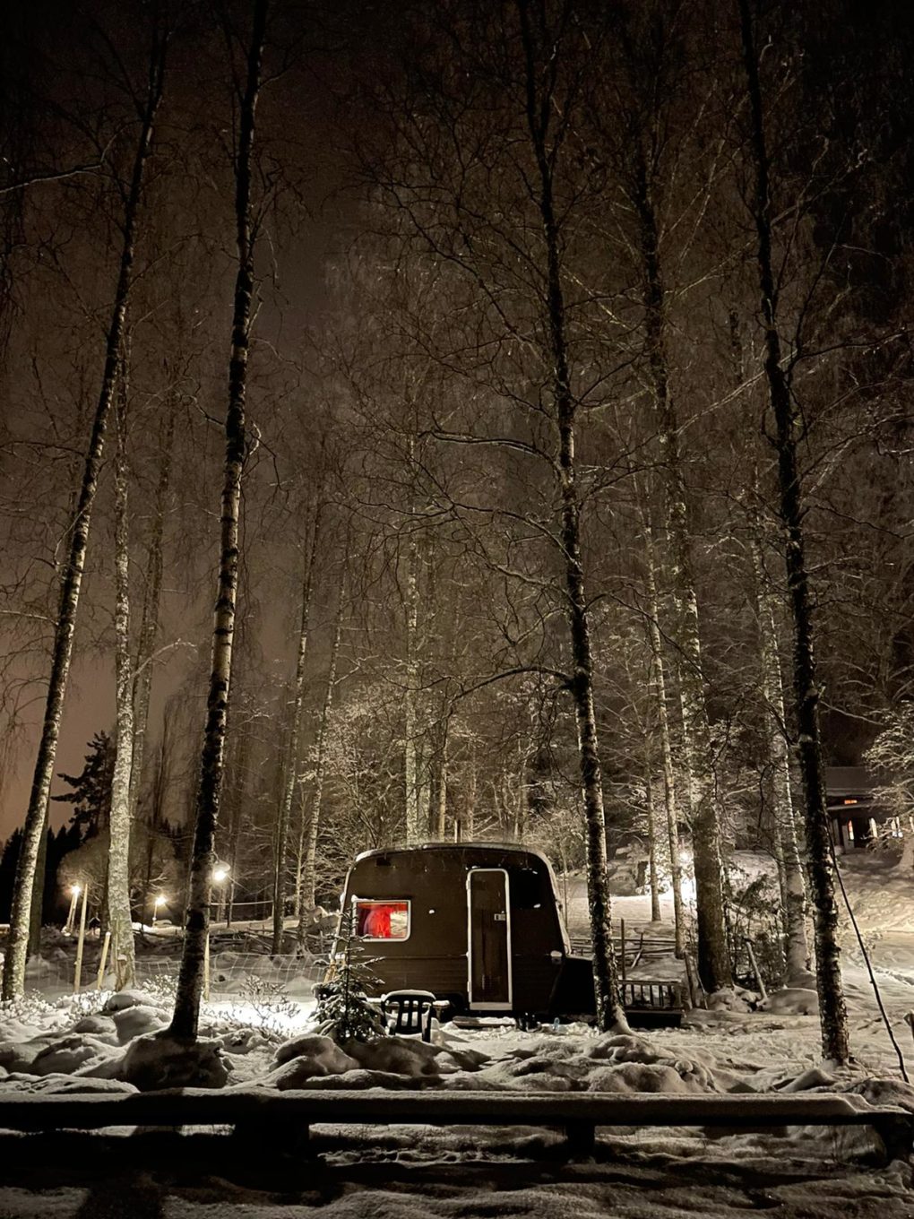 Vuokrattava kärrysauna metsäympäristössä iltavalaistuksessa.