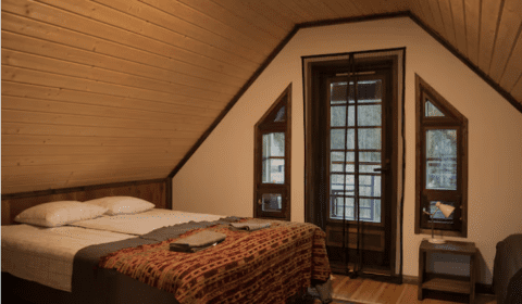 Vuokrattavan hirsimökin terassilla oleva riippukeinu